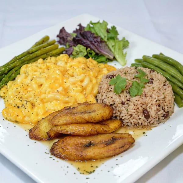 A plate with mac and cheese, rice and beans, fried plantains, asparagus, green beans, and salad.