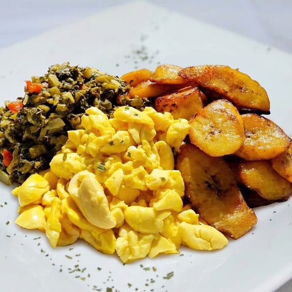 A plate of ackee and saltfish with callaloo and fried plantains.